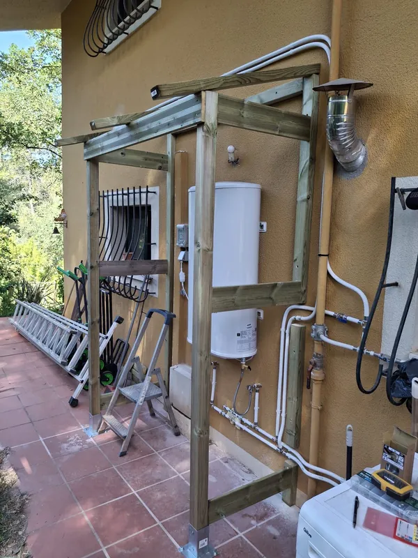 Instalação de termoacumulador exterior com canalização e estrutura de proteção em madeira
